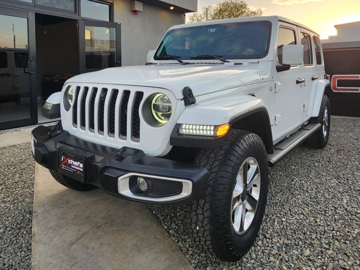 Jeep Wrangler Sahara 2021 blanco vista de frente en el lote de Ixchel's Automotriz